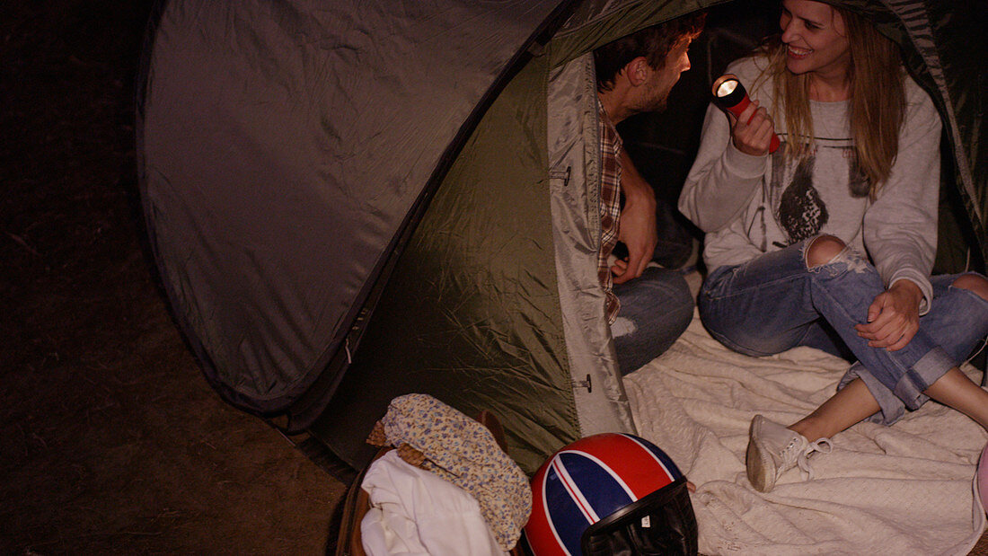 Young couple inside camping tent