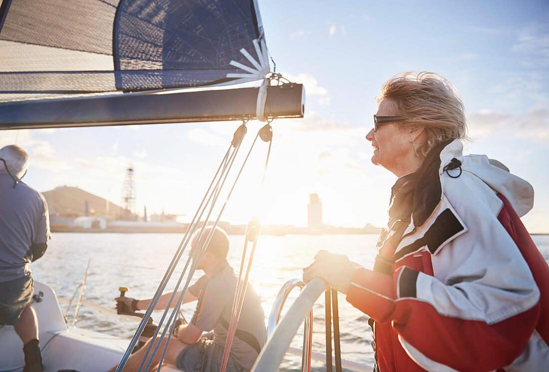 Woman sailing steering sailboat at helm