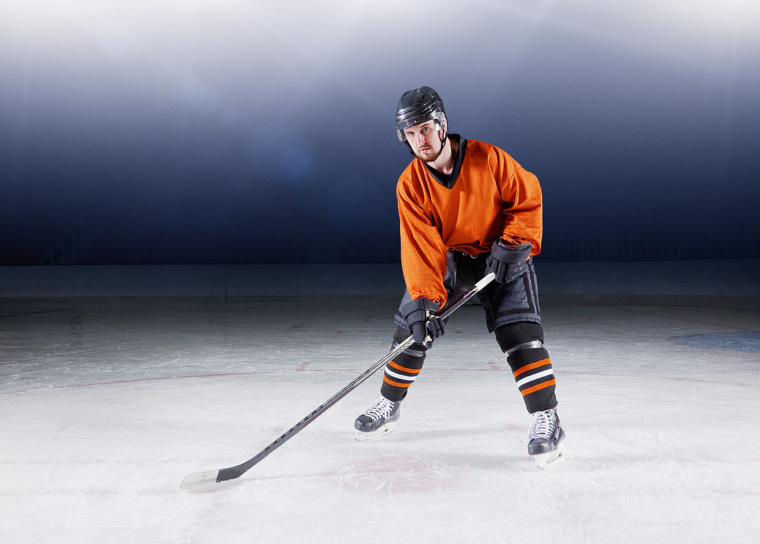 Hockey player in orange uniform on ice