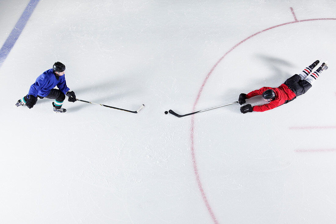 Hockey players diving for puck on ice