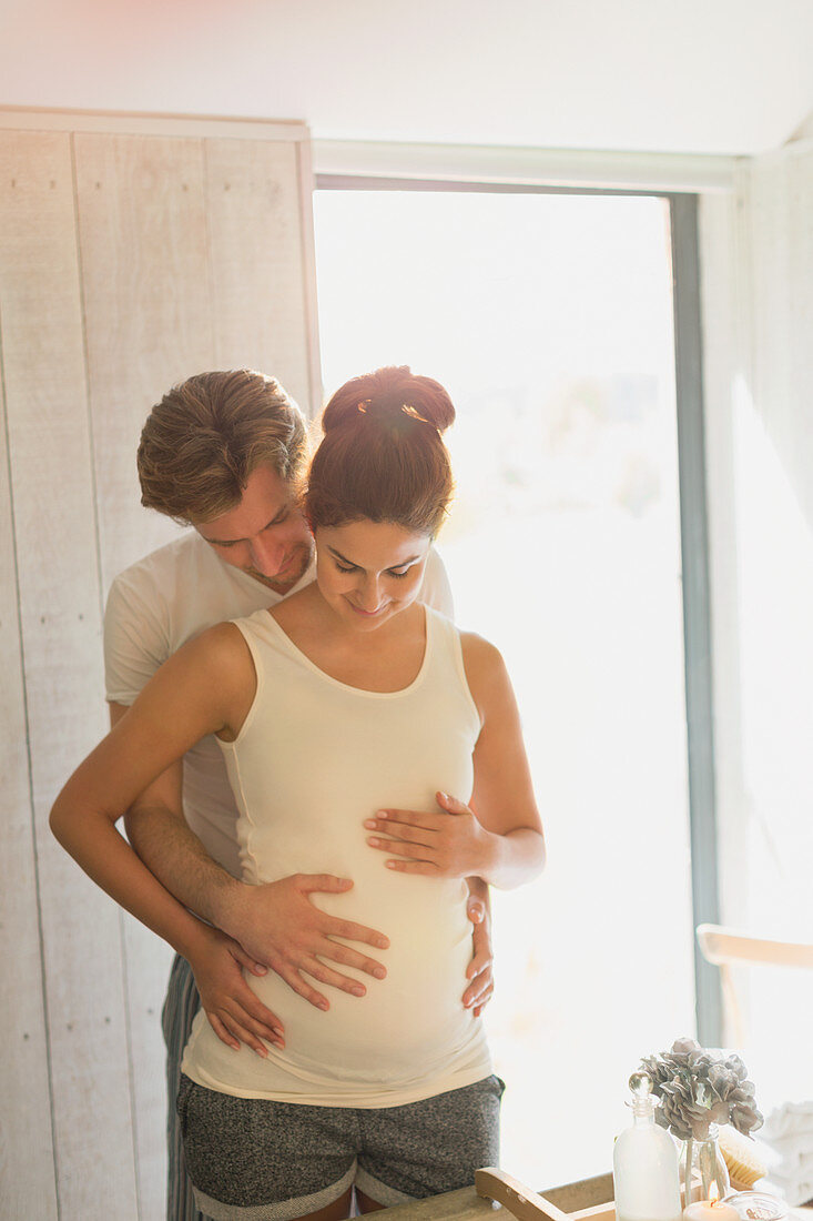 Pregnant couple holding belly