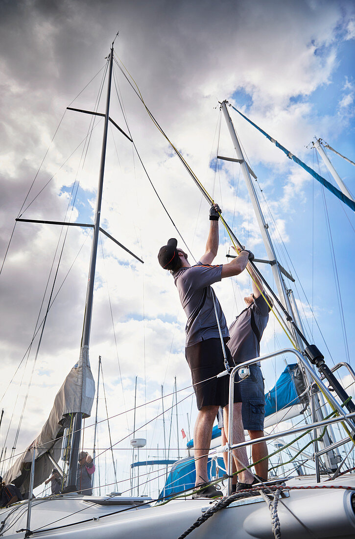 Men adjusting sailing equipment
