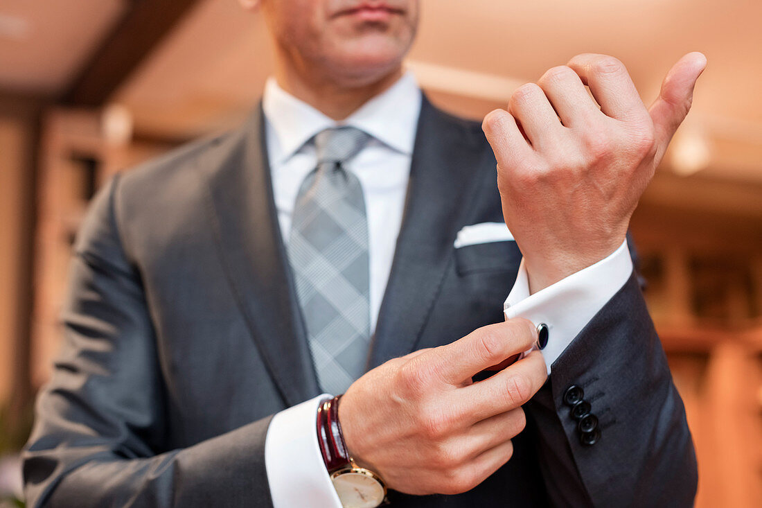 Businessman adjusting cufflinks