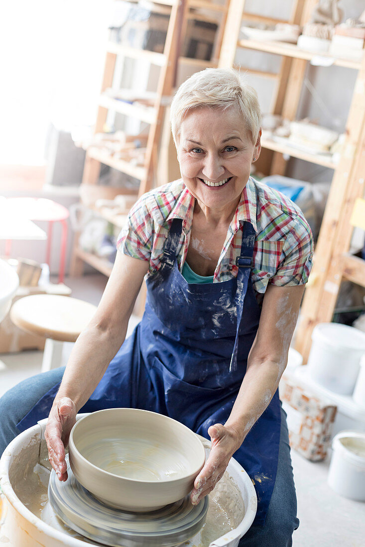 Senior woman using pottery wheel