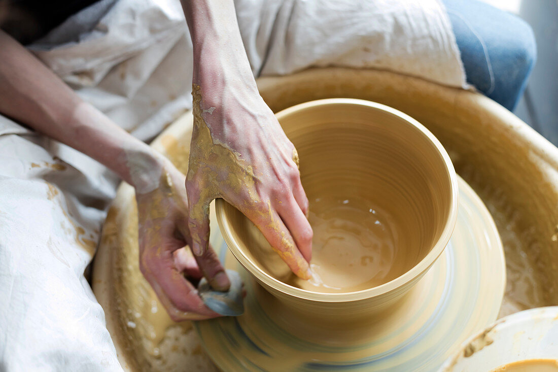 Overhead view woman using pottery wheel