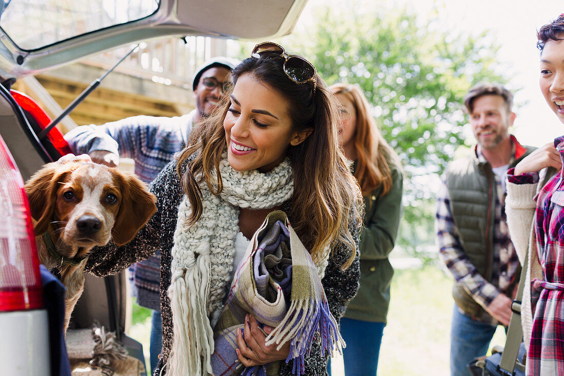 Friends with dog at back of car