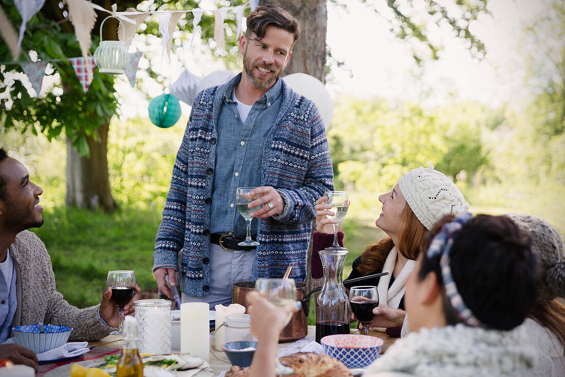 Man toasting friends at garden party