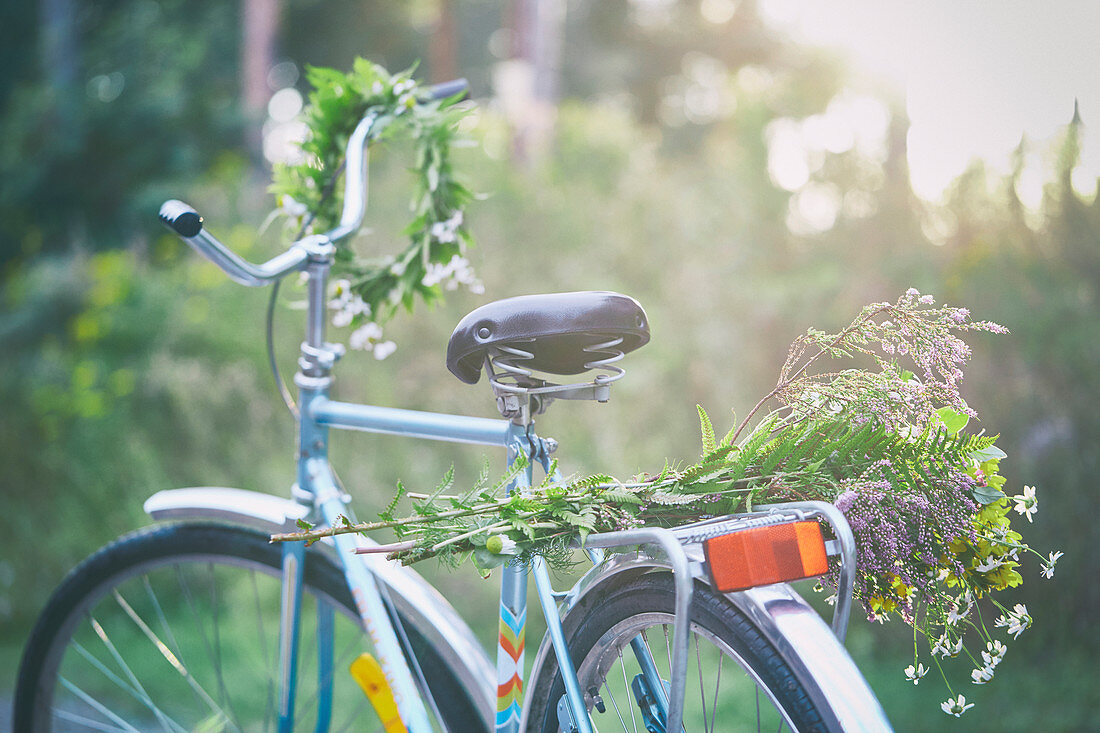 Flowers and garland on bicycle in garden