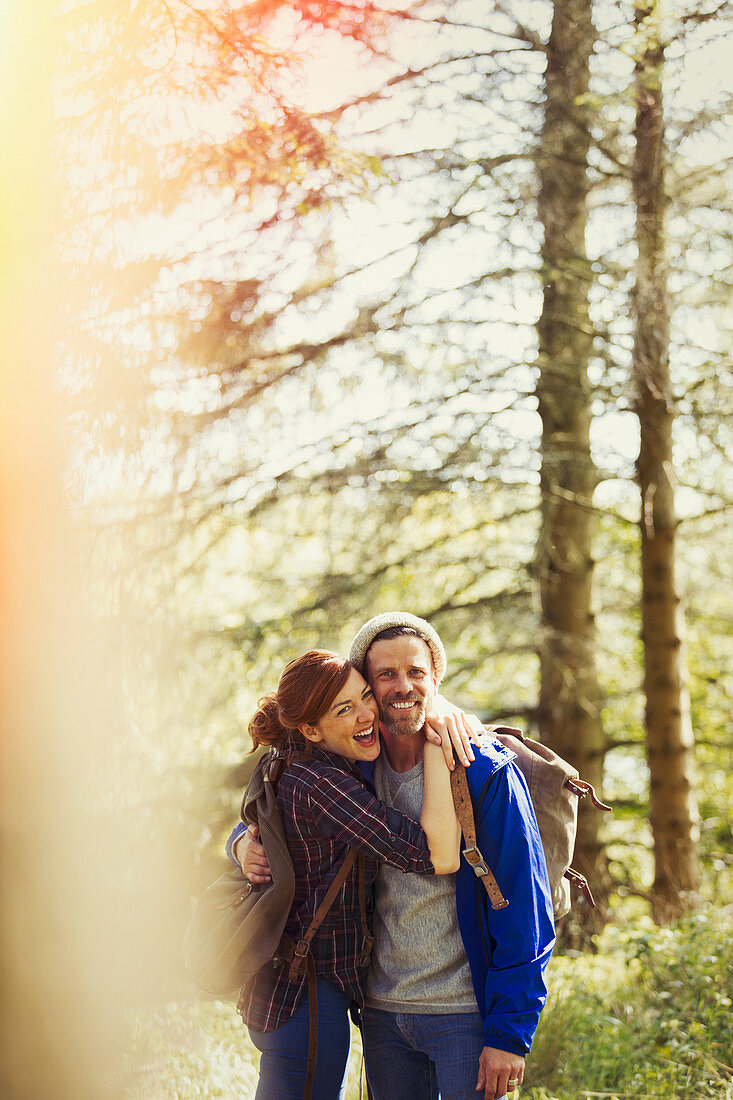 Couple with backpacks hiking in woods