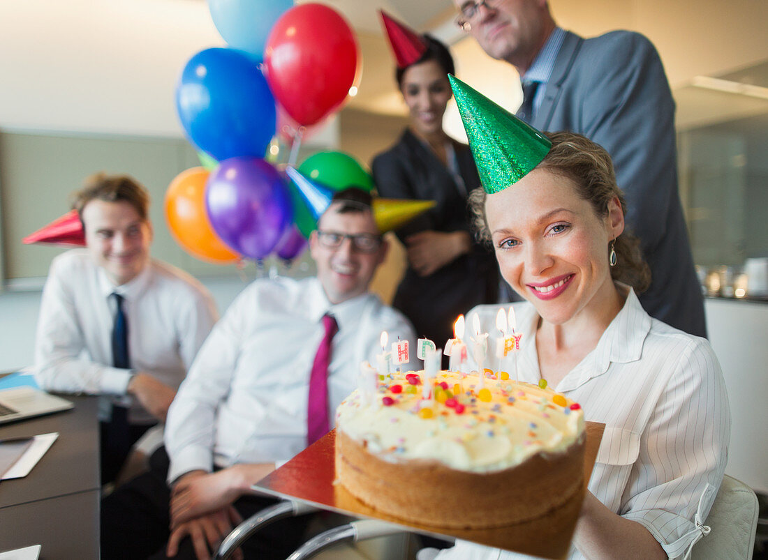 Businesswoman holding birthday cake