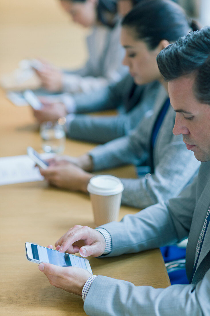 Businessman using cell phone in conference room