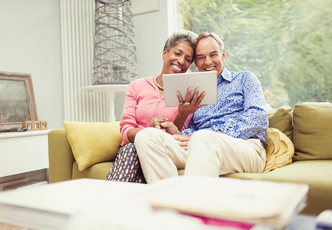 Smiling mature couple using digital tablet