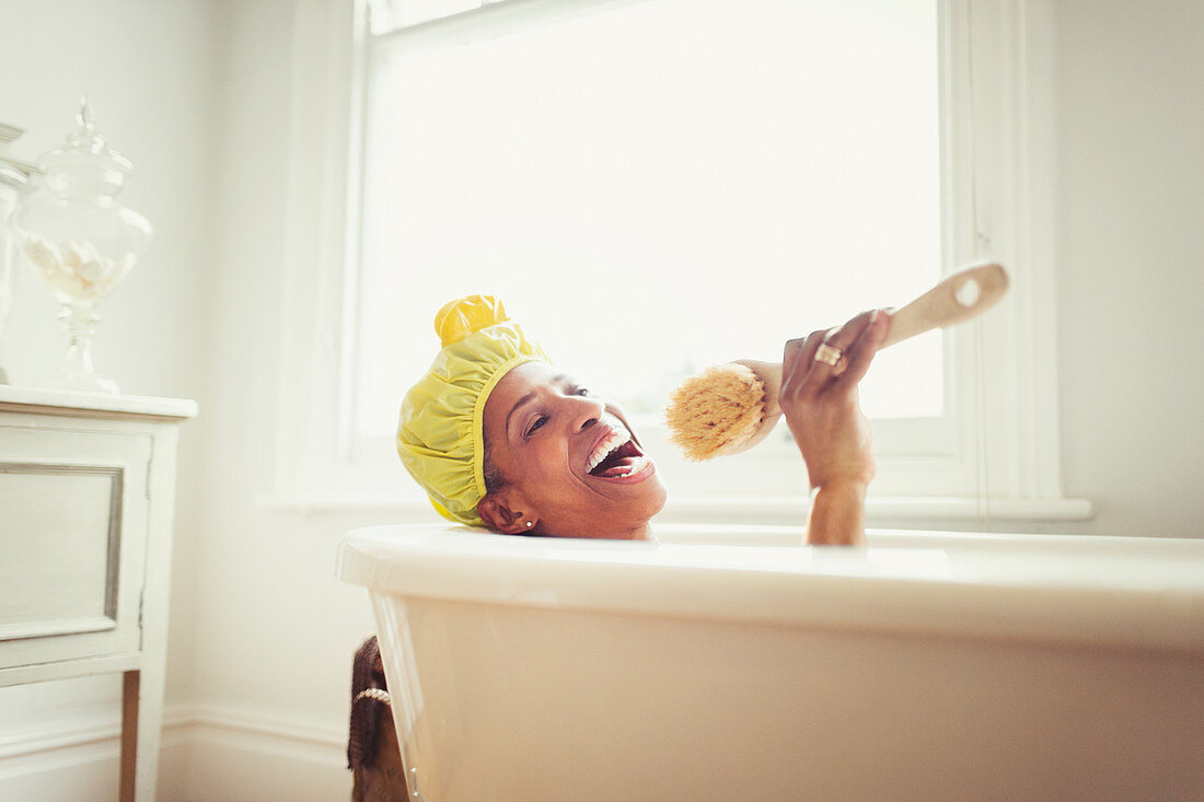 Playful mature woman singing in bathtub