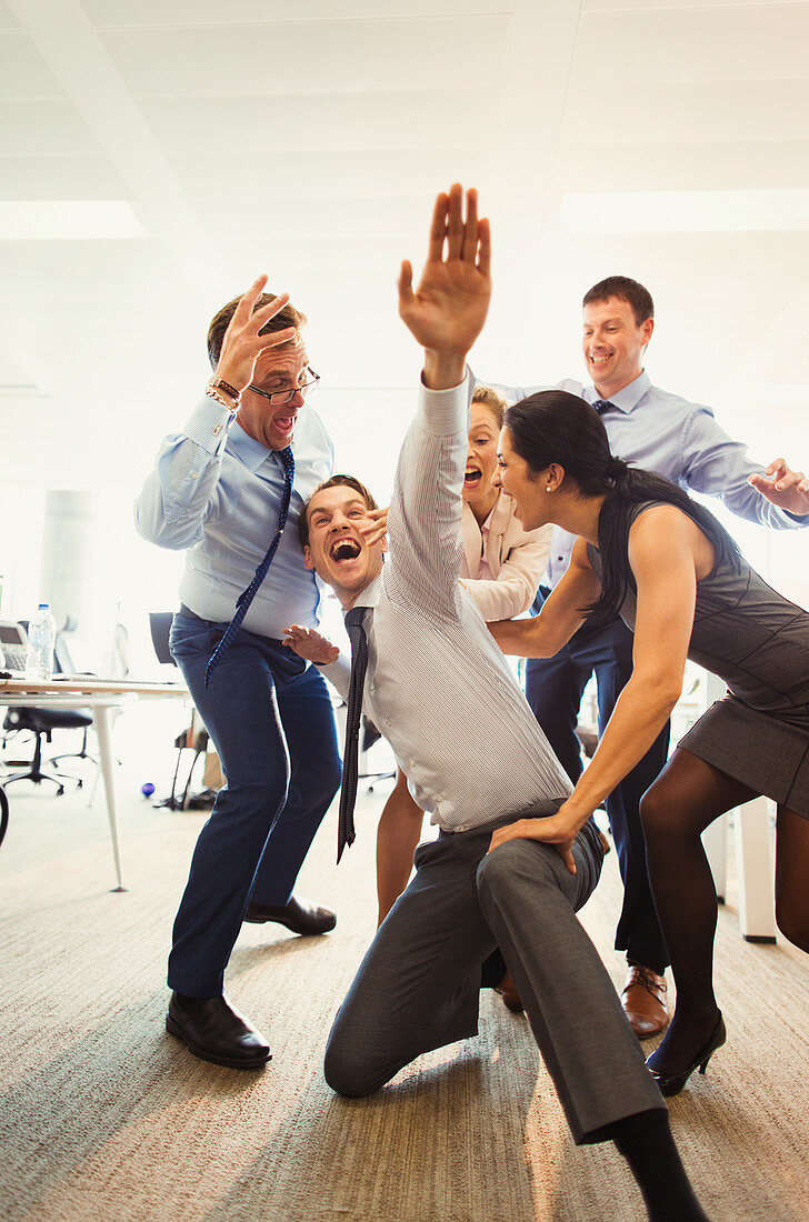 Business people celebrating and dancing in office