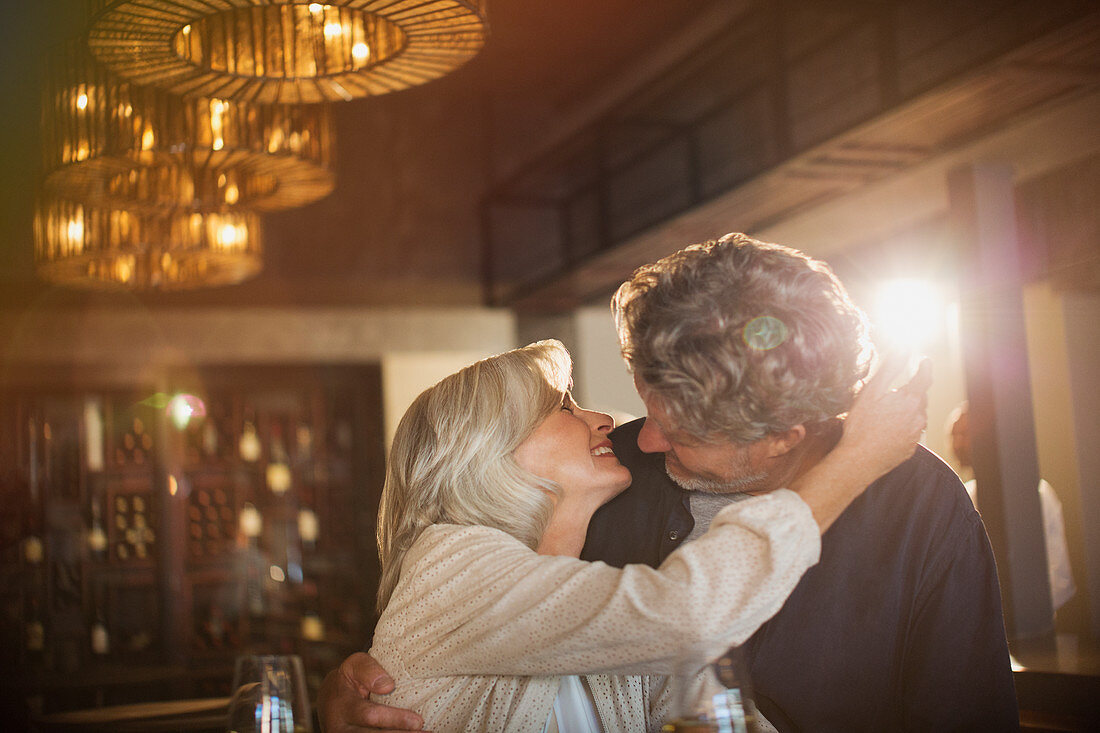 Senior couple hugging and kissing in bar
