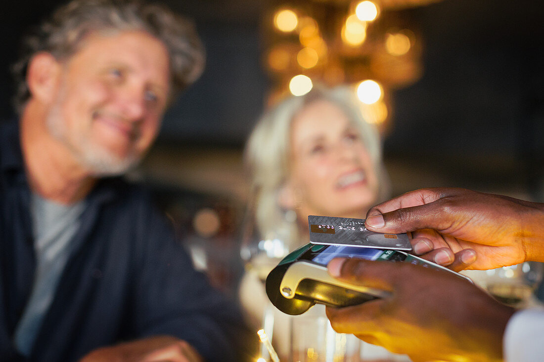 Couple paying waiter with credit card