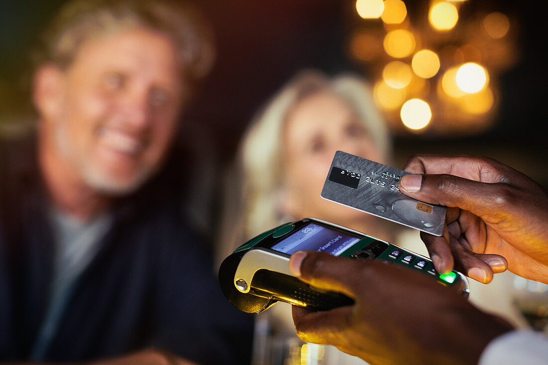 Close up couple paying waiter with credit card