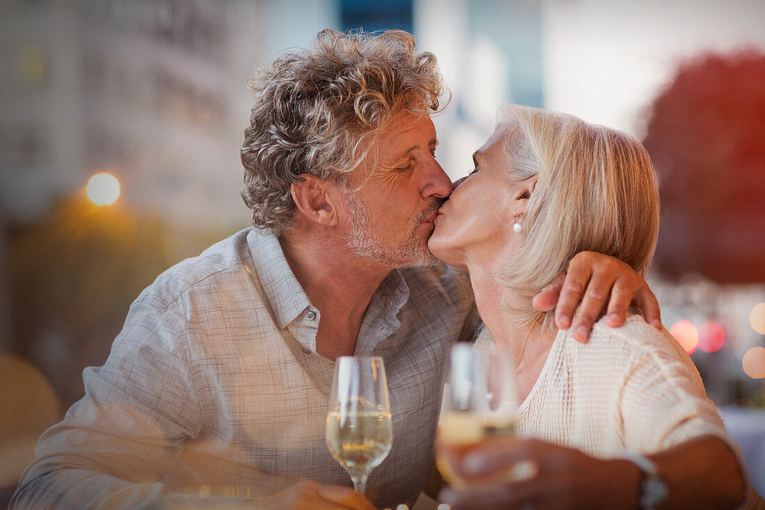 Senior couple kissing drinking white wine