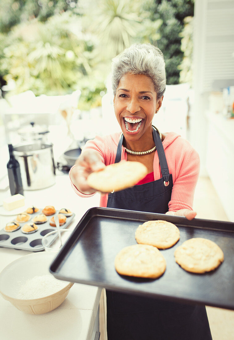 Mature woman baking cookies in kitchen