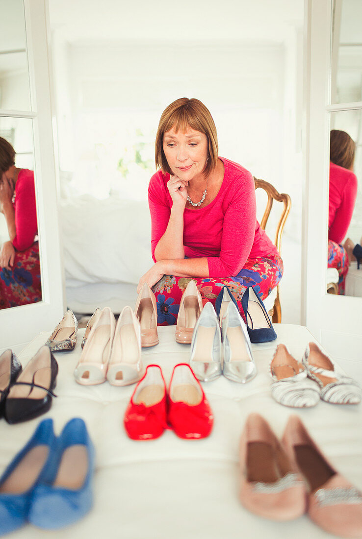 Mature woman deciding which shoes to wear