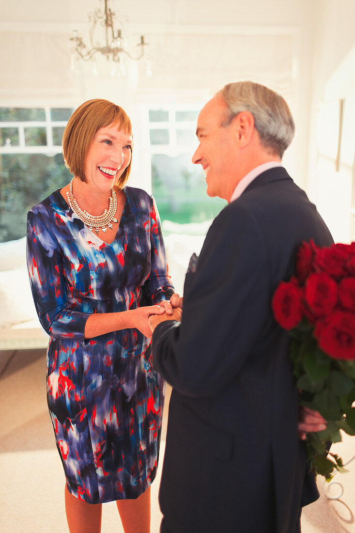 Well-dressed husband surprising wife with roses