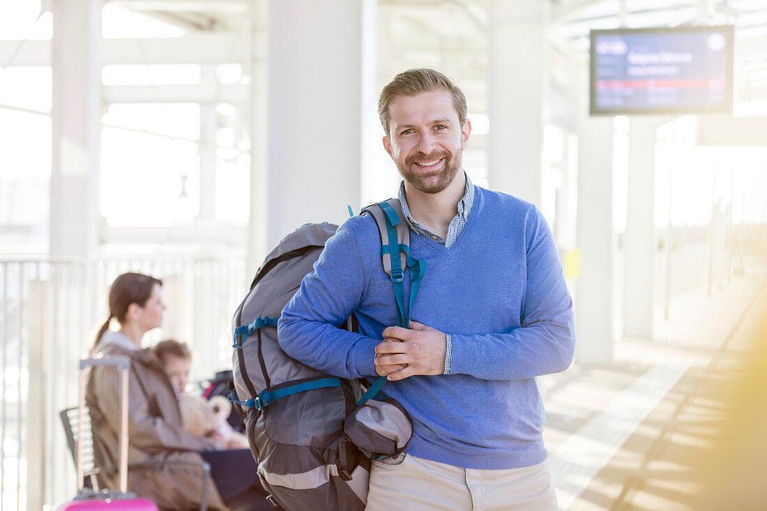 Portrait smiling man with backpack at airport