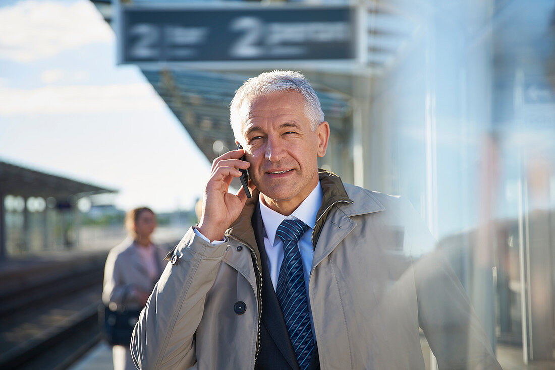 Businessman talking on cell phone outside airport