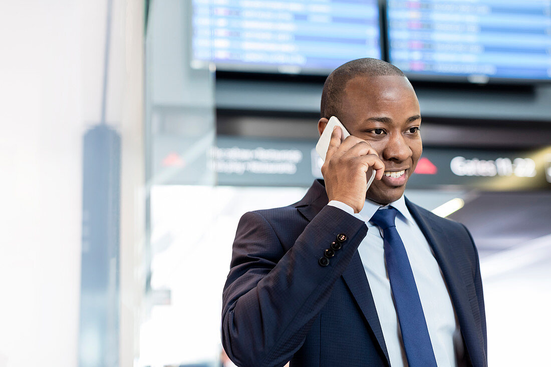 Businessman talking on cell phone in airport