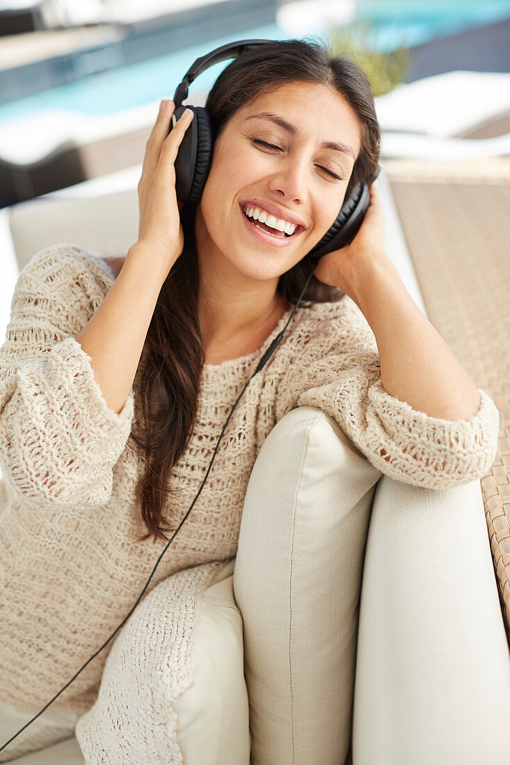 Carefree woman listening to music on sofa