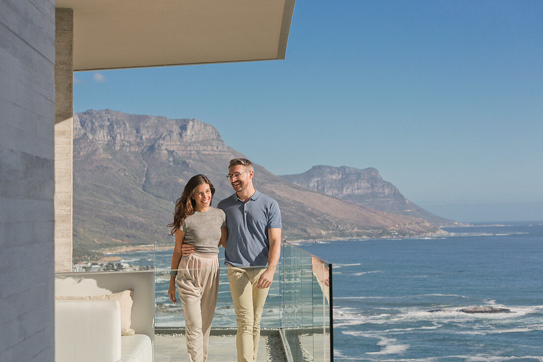 Smiling couple walking on luxury balcony