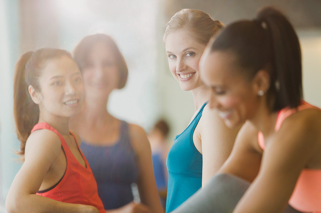 Smiling women talking in sunny gym studio