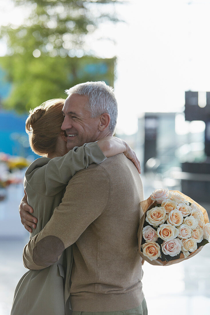 Couple with rose bouquet hugging