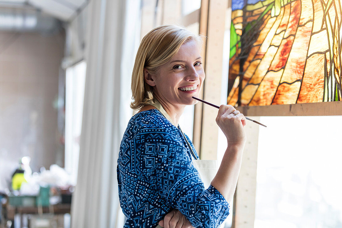 Portrait smiling artist working on stained glass