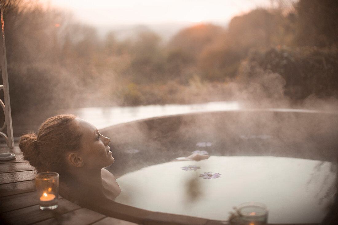 Serene woman soaking in steaming hot tub