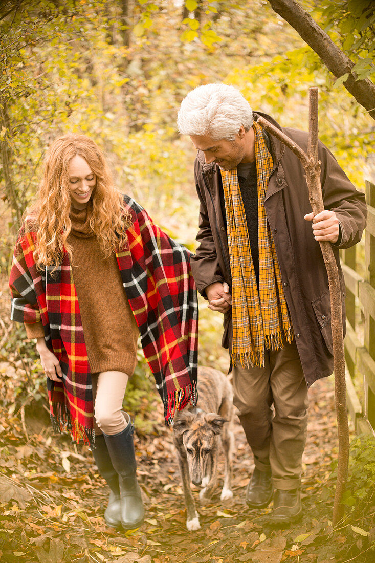 Couple with dog and walking stick in autumn woods