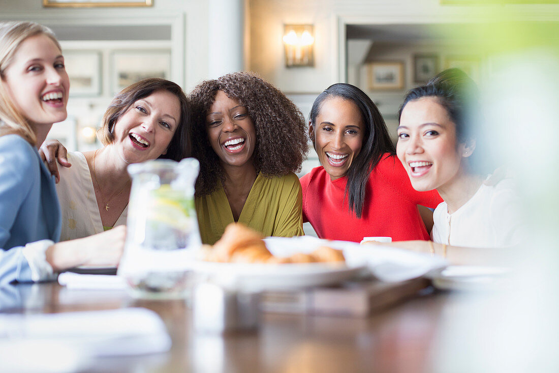 Portrait laughing women friends dining