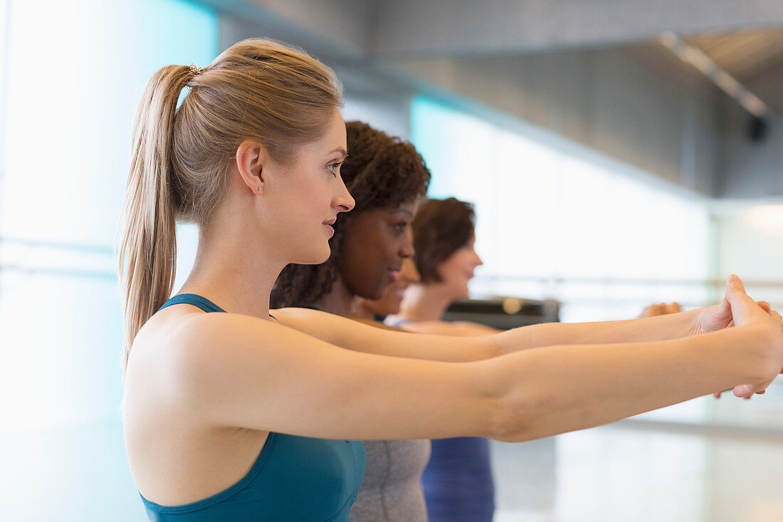 Women stretching arms in exercise class gym studio