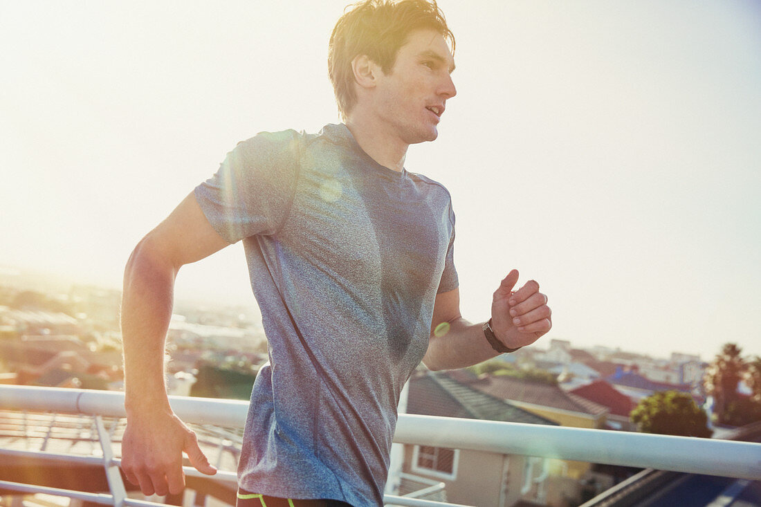 Sweaty male runner running at sunrise