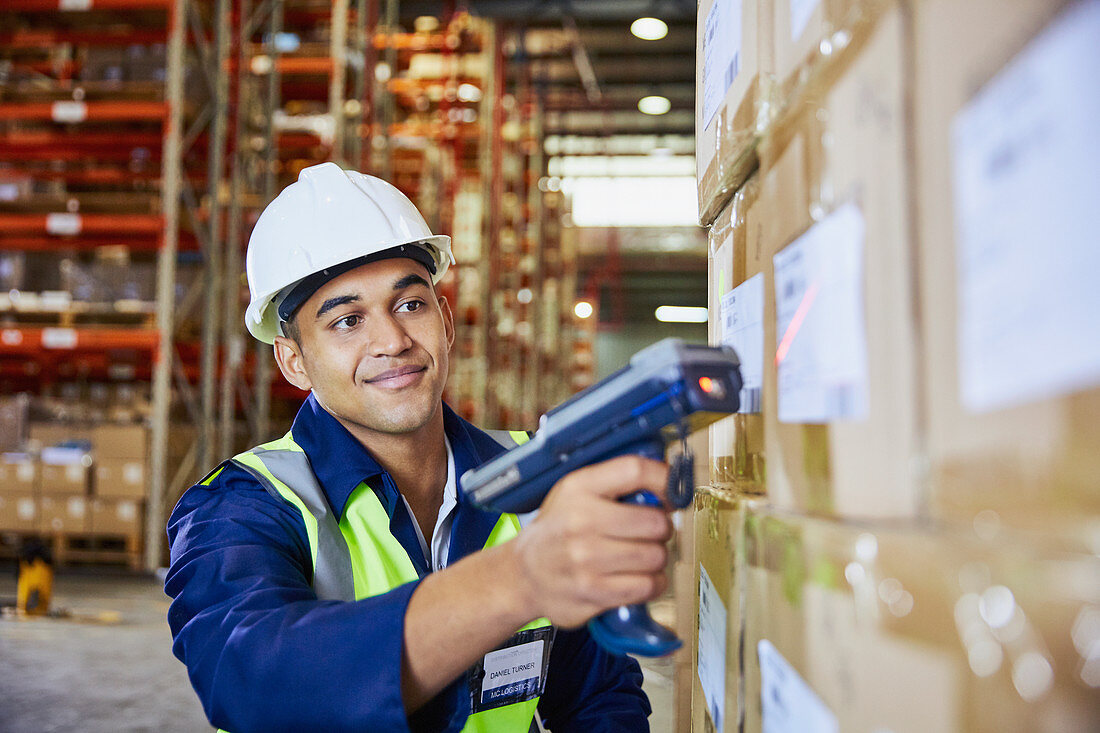 Worker with scanner scanning boxes