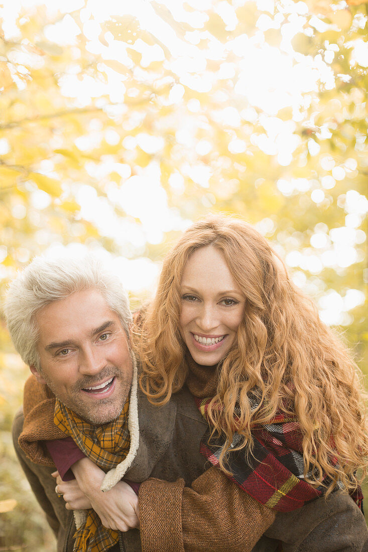 Portrait smiling playful couple piggybacking