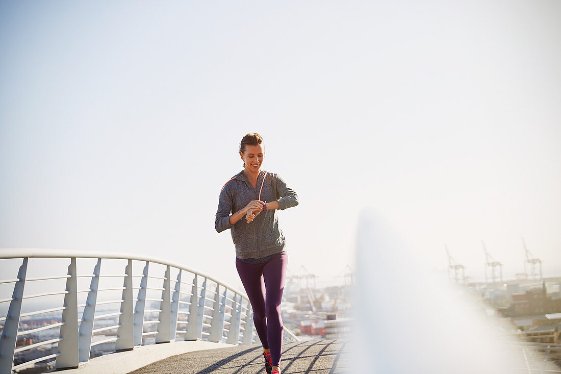 Female runner checking smart watch fitness tracker