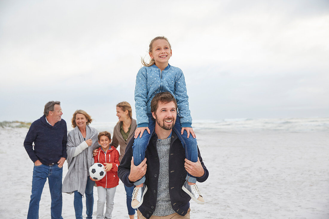 Multi-generation family walking on winter beach