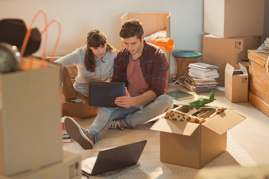 Young couple surrounded by moving boxes