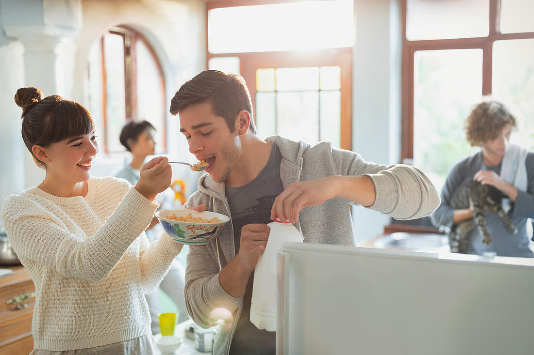 Young woman feeding boyfriend cereal