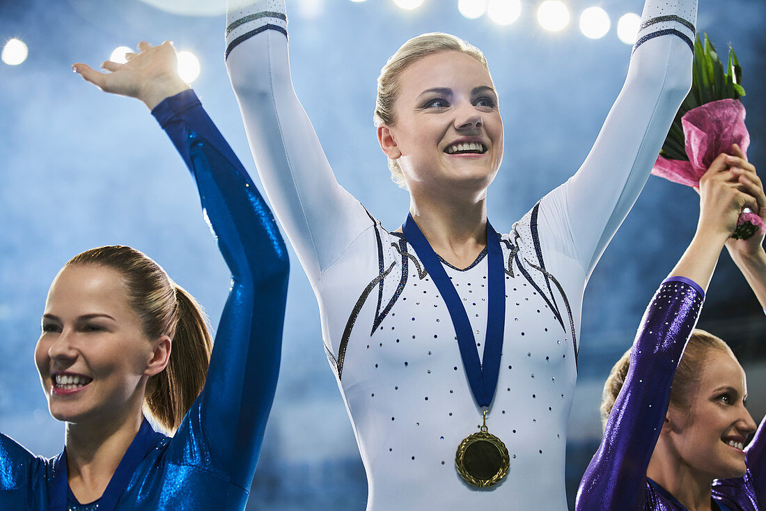Female gymnasts waving on winners podium