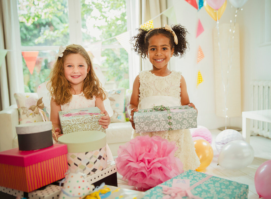 Portrait smiling girls holding birthday gifts