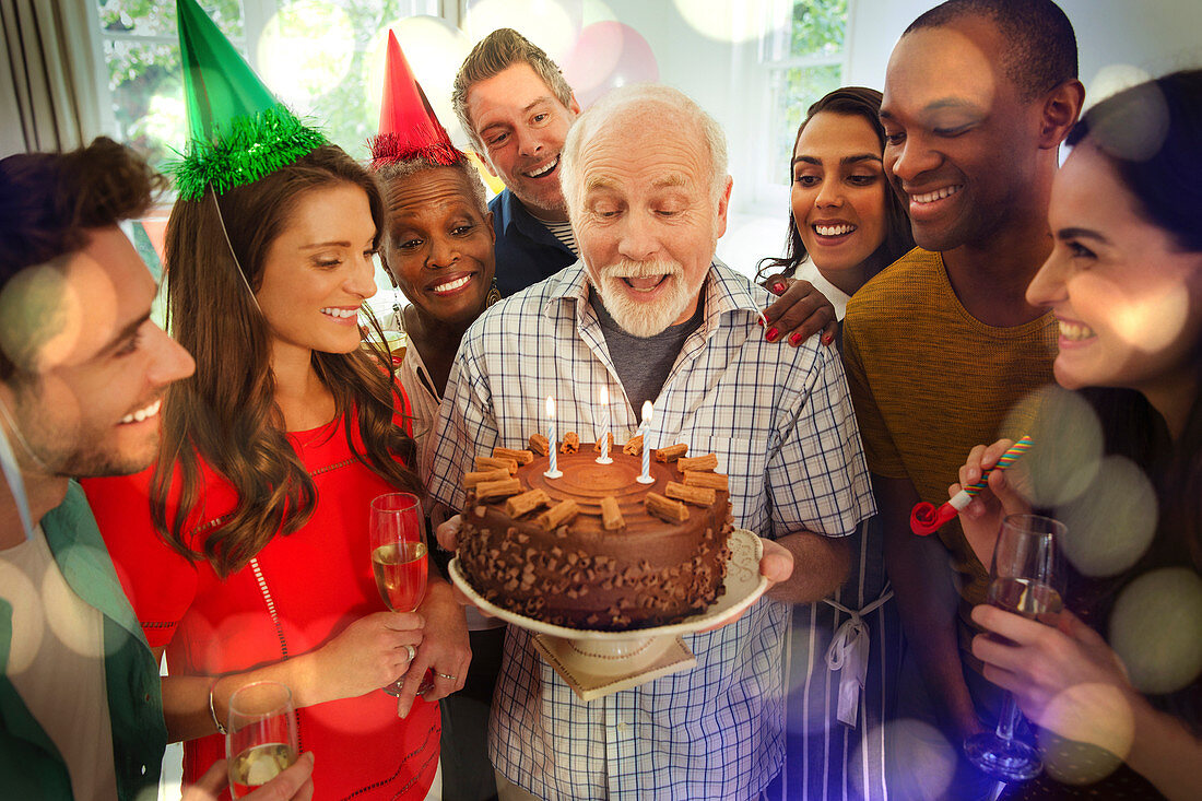 Family watching man blow out birthday candles