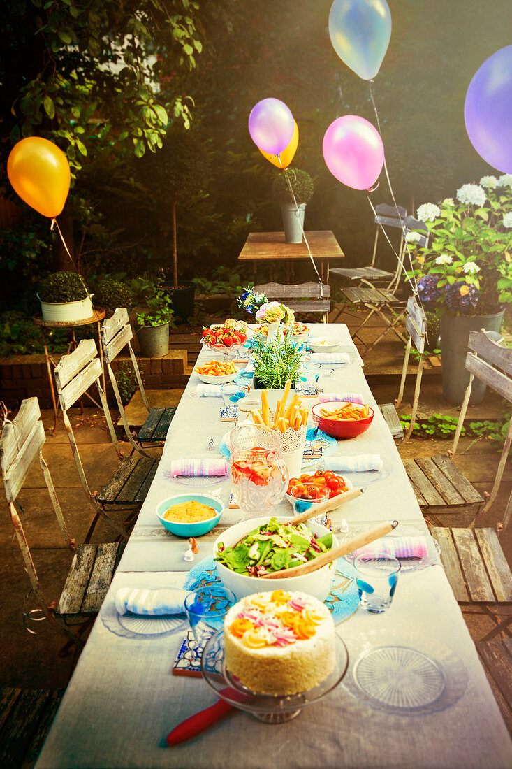Balloons and food at garden party patio table