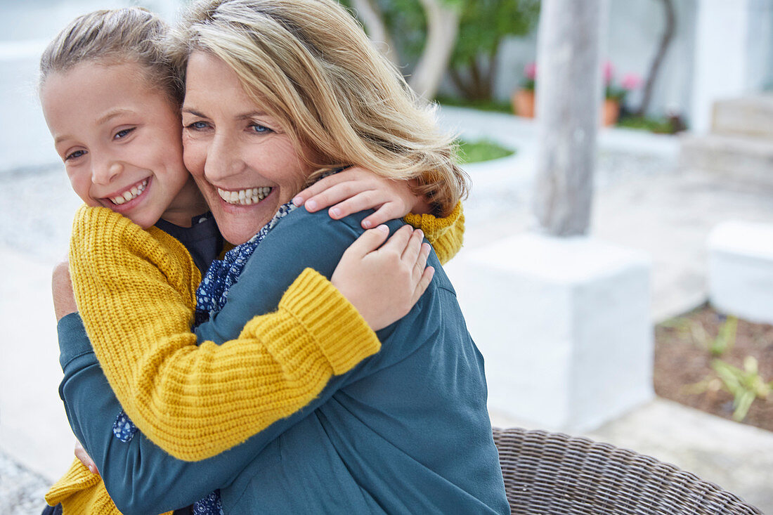 Enthusiastic grandmother and granddaughter hugging