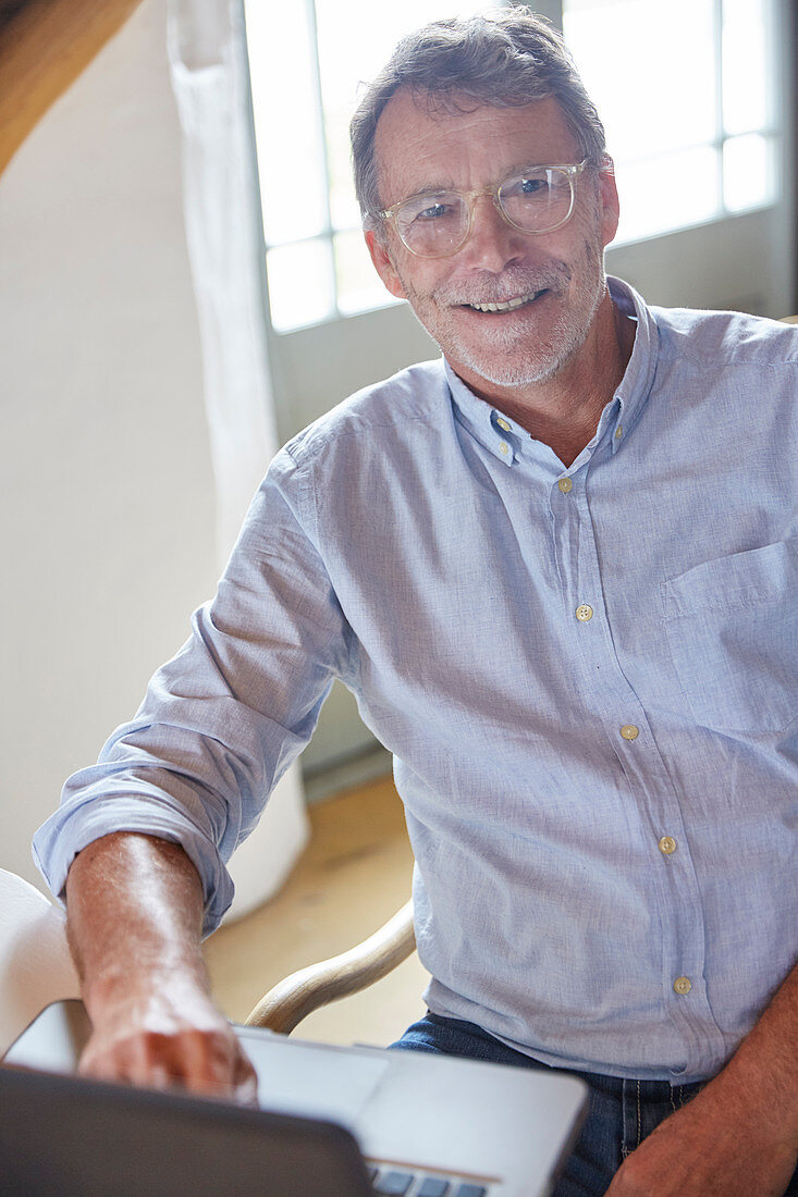 Portrait smiling senior man using laptop